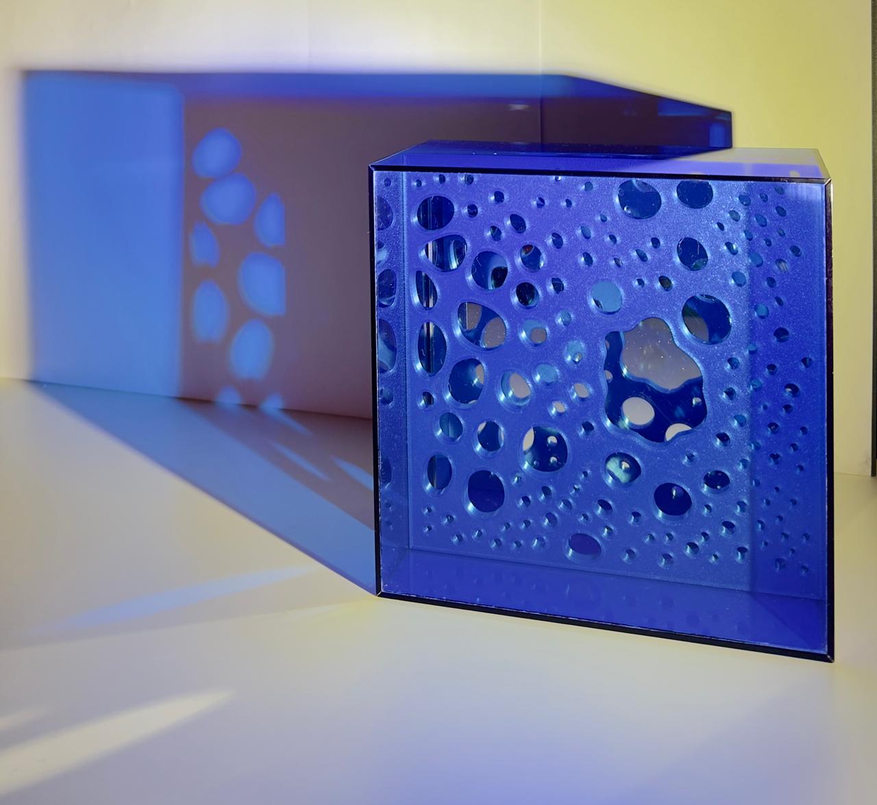 Caixa de luz azul de Cris Prado projetando formas orgânicas sobre a parede