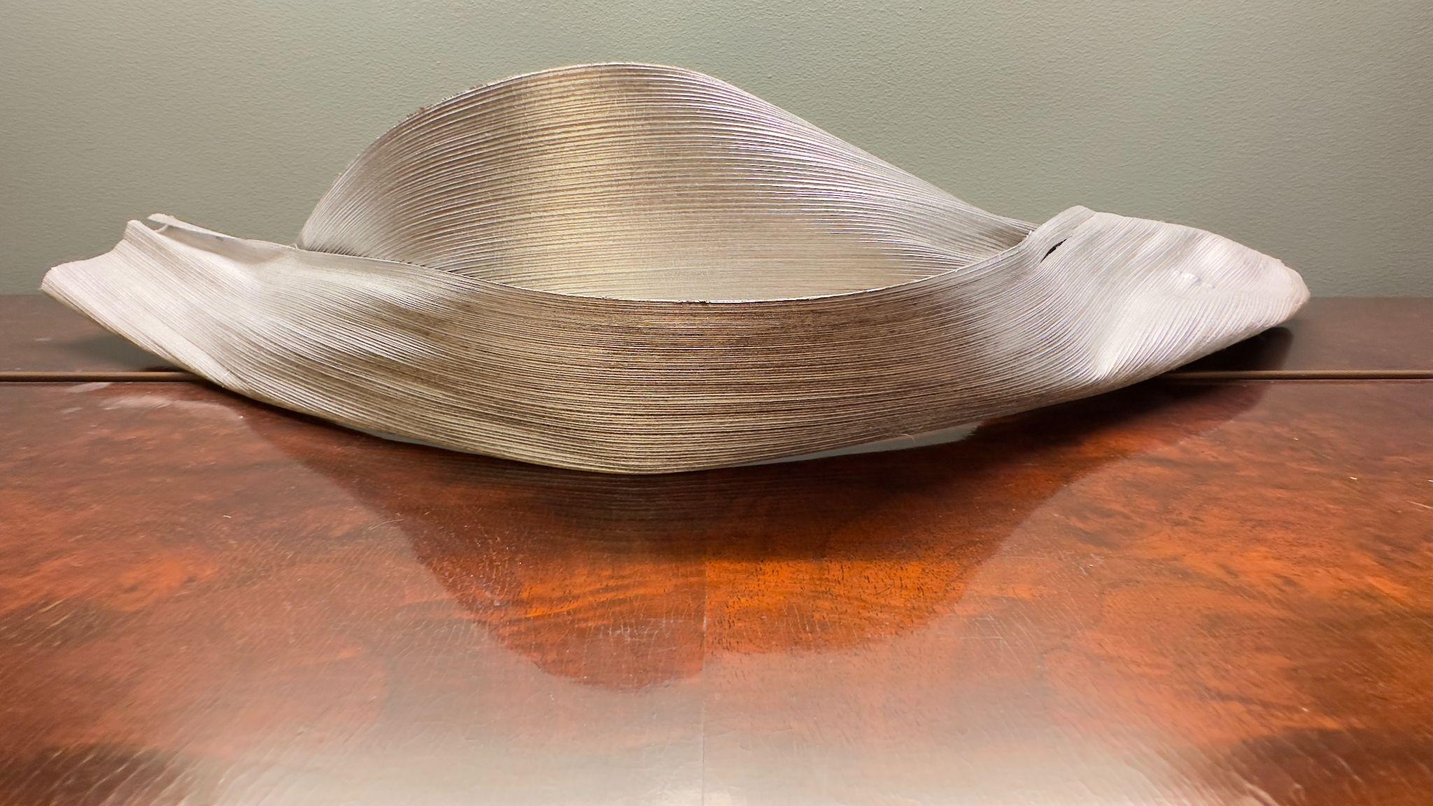 Escultura orgânica clara sobre mesa de madeira